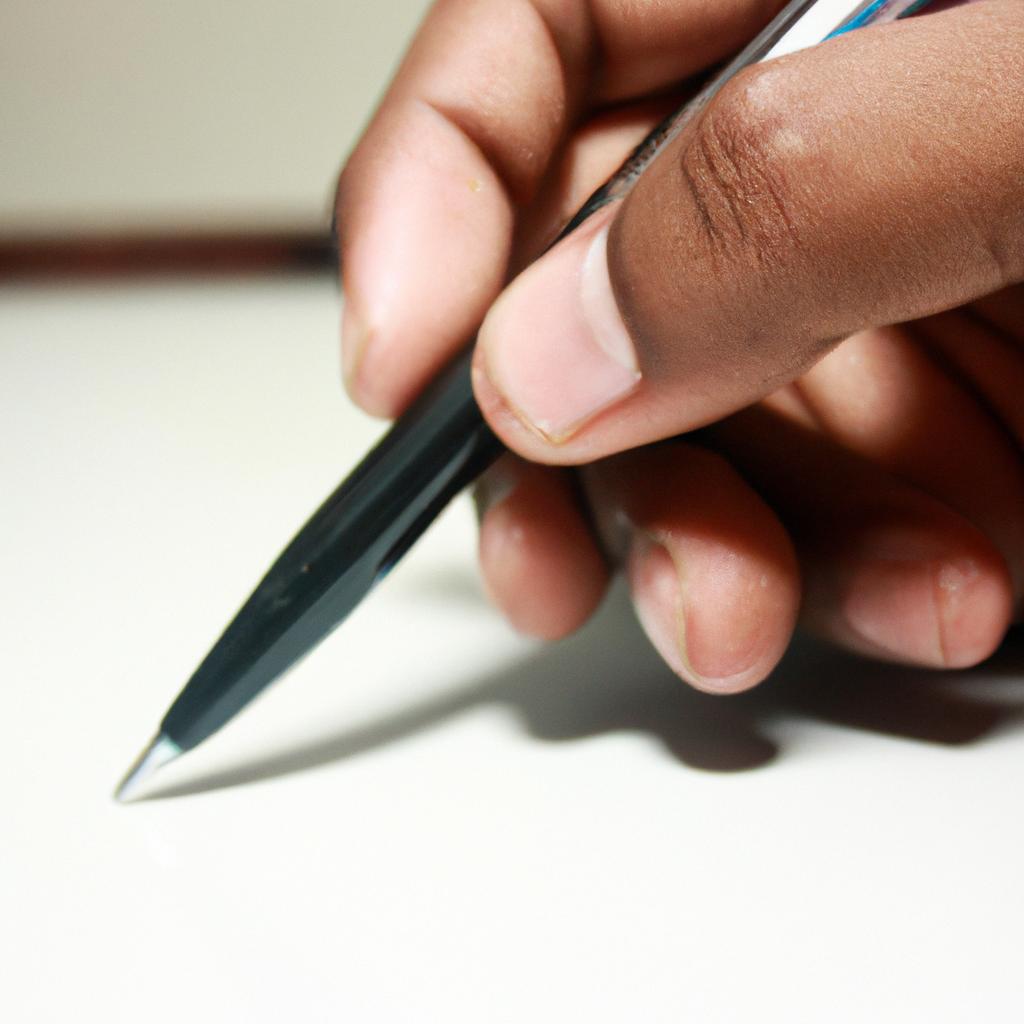 Person holding a writing pen